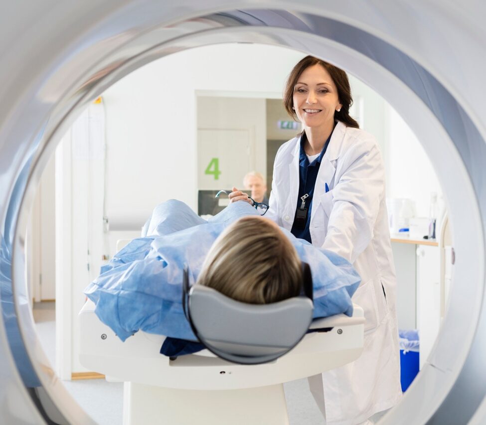 Female Doctor Looking At Patient Undergoing CT Scan